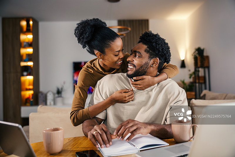 一对非裔美国夫妇在家中拥抱工作图片素材
