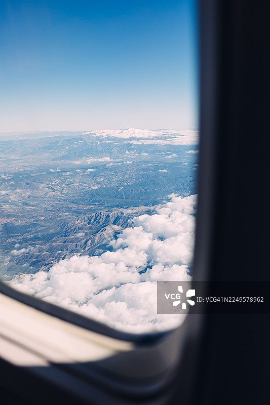 从飞机窗户座位看到的雪山和山谷的鸟瞰图图片素材