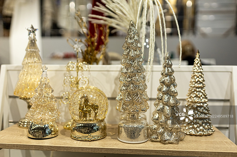 优雅的银色圣诞树装饰品和闪闪发光的饰品摆放在木制展示桌上图片素材