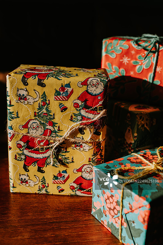 精美的圣诞礼物用复古风格包装纸包裹，放在木质表面上图片素材