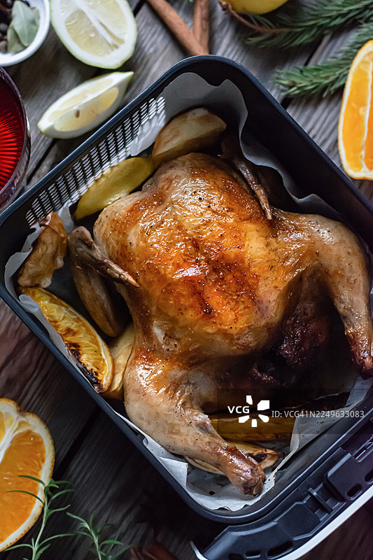 烤鸡或火鸡配水果、红酒和香料，用于感恩节和圣诞节的节日餐桌。图片素材