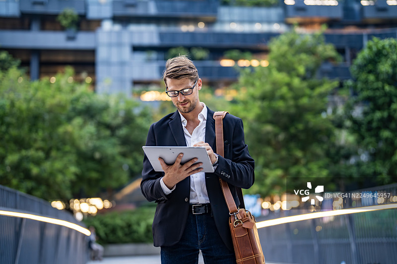 专业的商人在城市户外使用平板电脑图片素材