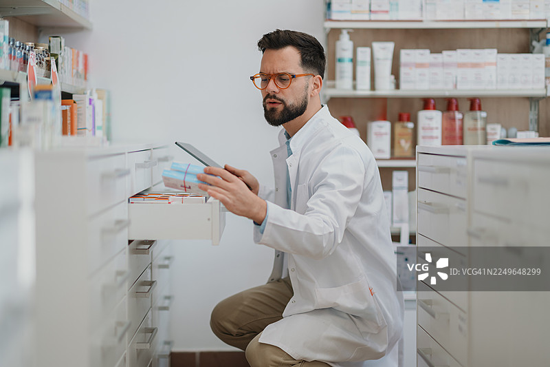 药剂师使用平板电脑清点药品库存图片素材