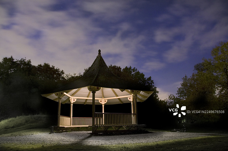 夜晚的凉亭，内部灯火通明，背景是深蓝色的天空。图片素材