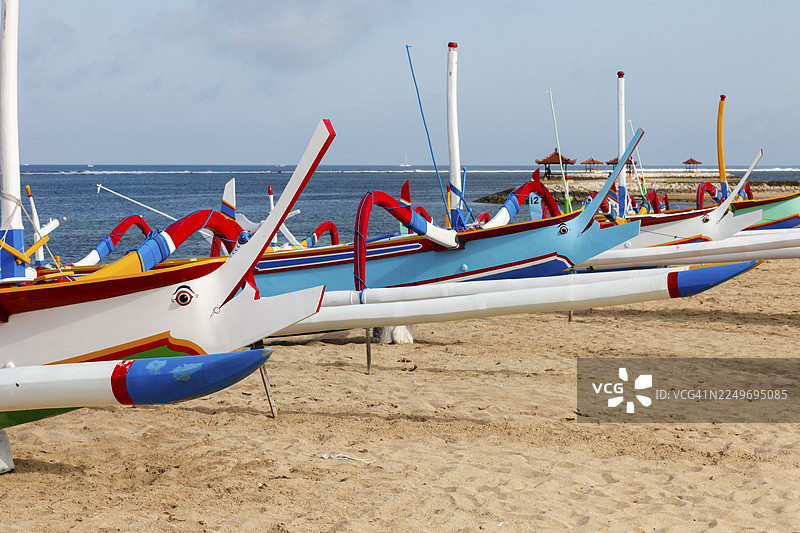 色彩鲜艳的独木舟渔船（Jukung）在印度尼西亚巴厘岛的萨努尔海滩图片素材