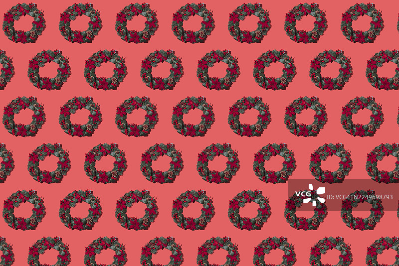 红色背景上的圆形圣诞花环图案。庆祝，装饰，树，树枝，杉树，松树，圣诞老人，叶子和饰品。图片素材