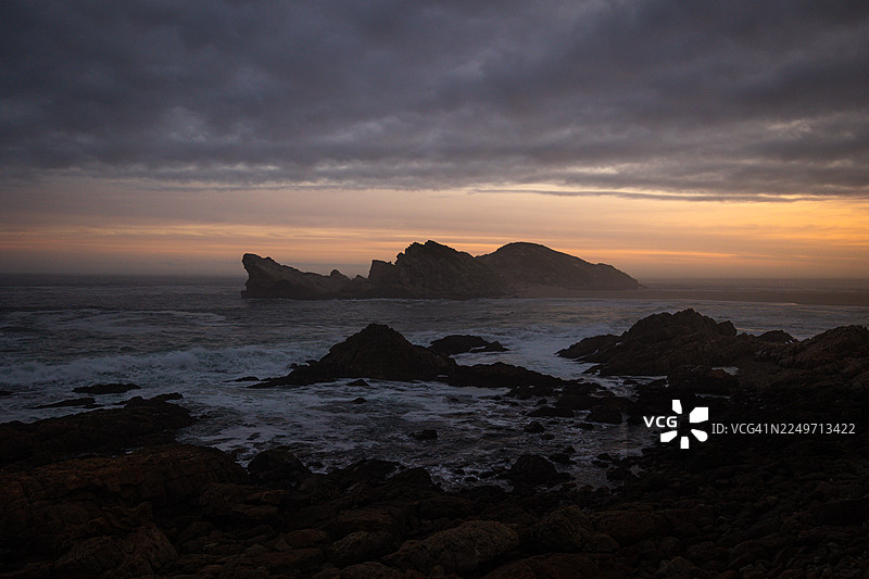 南非罗伯格自然保护区风景优美的海岸步道，在金色时刻拍摄——有岩石悬崖、木制栈道和海景图片素材