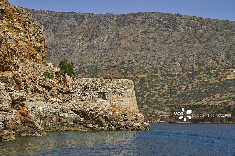 岩石海岸景观中的古老堡垒，周围环绕着丘陵地带和平静的蓝色海水，威尼斯海堡，莱珀岛，斯皮纳隆加，埃卢达湾，米拉贝罗湾，东克里特，克里特，希腊岛屿，希腊图片素材