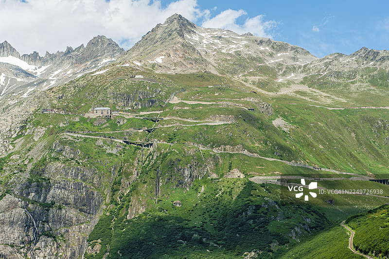 夏季，阿尔卑斯山口弗尔卡山口的道路景观，山口有急弯和发夹弯，位于树线以上的陡峭山坡上，图中为弗尔卡山口的山顶，瓦莱州，瑞士图片素材