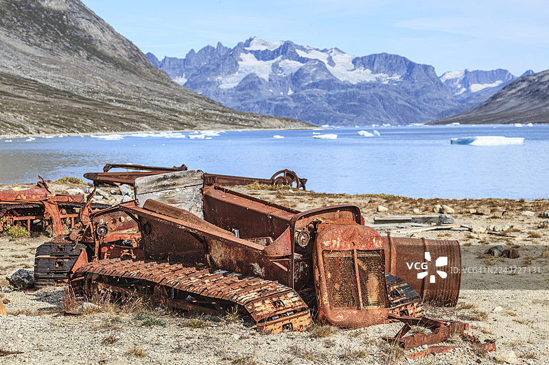 二战时期美国空军基地的遗迹，锈迹斑斑的汽车和油桶，坐落在陡峭山前的峡湾中，伊卡特克峡湾，格陵兰东部，格陵兰图片素材