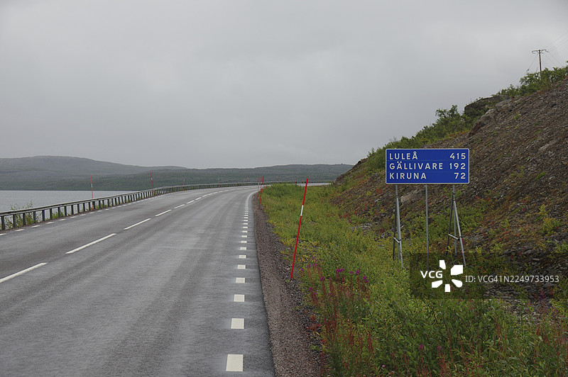 阴云密布天空下的乡村孤独小路，路标指向吕勒奥和基律纳，拉普兰秋季，托讷湖，阿比斯库，瑞典图片素材