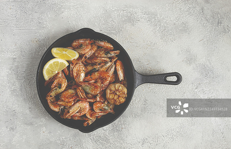 炸虾，在铸铁锅里，啤酒配虾，报纸上，在灰色的桌子上，无人图片素材