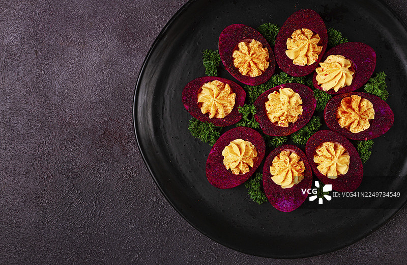 酿入馅料的鸡蛋，用甜菜根汁染色，呈现紫色，撒上火龙果粉，俯视角度，特写，无人图片素材