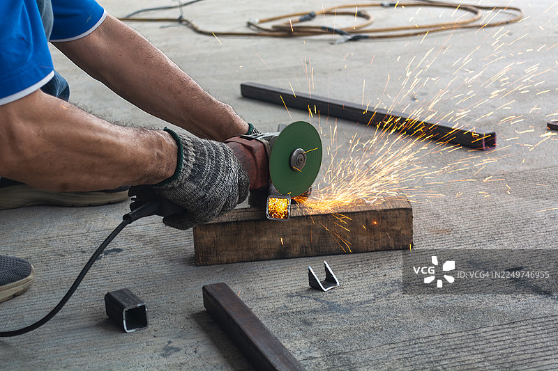 专业砌砖工用切割机切割钢筋，迸射出大量彩色火花图片素材