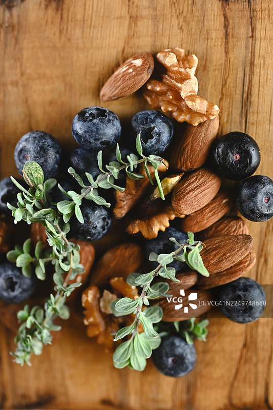 木板上的蓝莓、杏仁、核桃和百里香图片素材