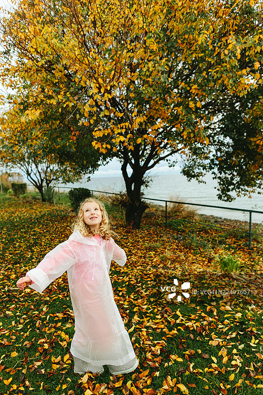 一个孩子在秋天树下快乐地旋转图片素材