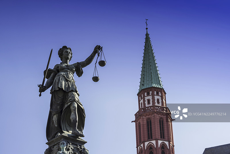正义女神雕像，手持天平，位于罗马广场的正义女神喷泉之后是尼古拉教堂，德国法兰克福，黑森州图片素材