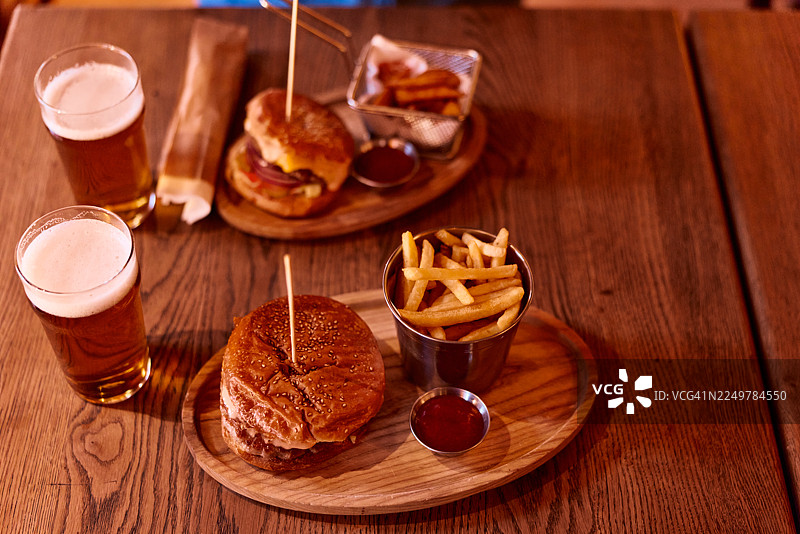 在酒吧享用汉堡、炸薯条和冰镇啤酒图片素材