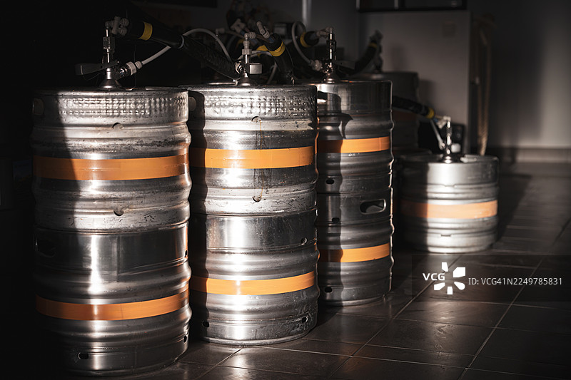 一排排不锈钢啤酒桶连接着软管，放置在法国一家精酿啤酒厂内图片素材
