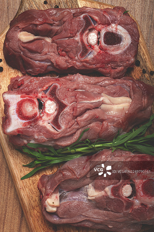 生牛排，带骨牛犊颈肉，新鲜肉类，放在砧板上，俯视视角，无人图片素材