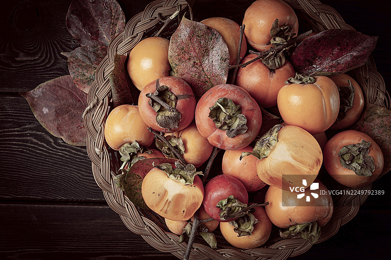 篮子里的新鲜柿子，带有叶子，俯视角度，无人图片素材