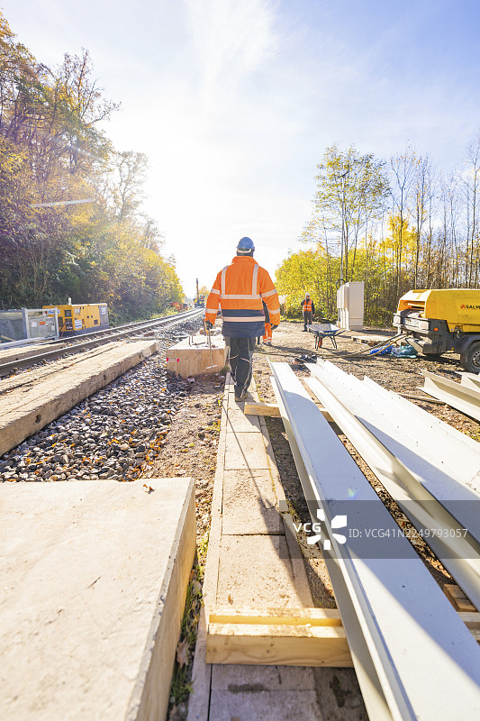 晴朗天气下，人们在铁轨旁建筑工地上穿着防护服，这里是德国黑森林卡尔夫的赫尔曼·黑塞铁路蝙蝠隧道建筑工地。图片素材