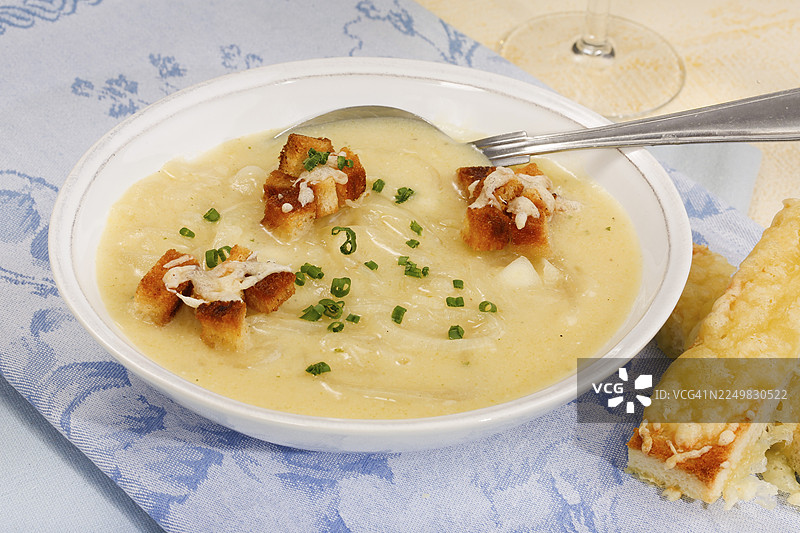 巴登美食，南德菜系，巴登洋葱汤配饼干、烤面包丁、炸油面包块，美味，典型的巴登风味，汤盘，勺子，奶油状，奶油，切碎的细香葱，奶酪烤面包块，白面包，传统美食，食物图片素材