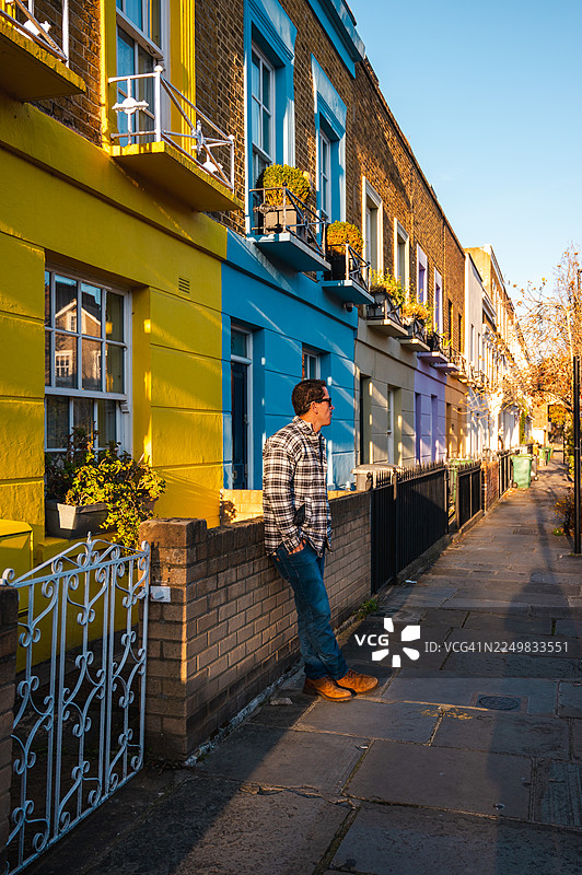 卡姆登镇色彩缤纷的房屋前的一名男子图片素材