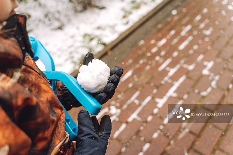 孩子用蓝色雪球制造器制作雪球图片素材
