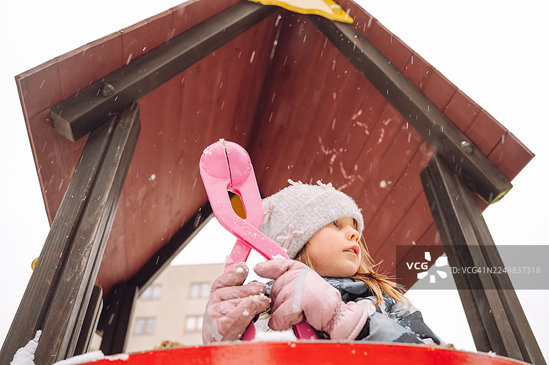 小女孩在冬天的游乐场玩雪球制造器图片素材