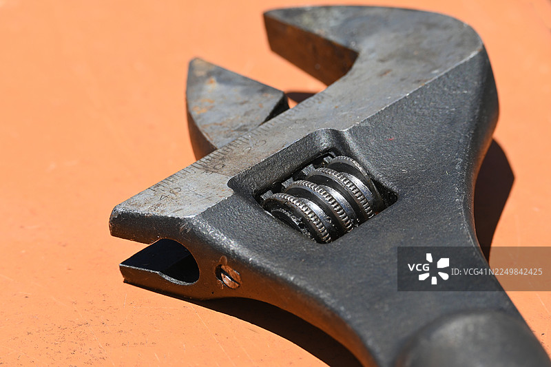 可调节扳手放在棕色表面上图片素材