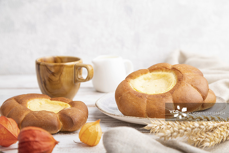 奶油卷配咖啡，背景为白色木质、水泥及亚麻布。侧面视角，特写，选择性对焦图片素材