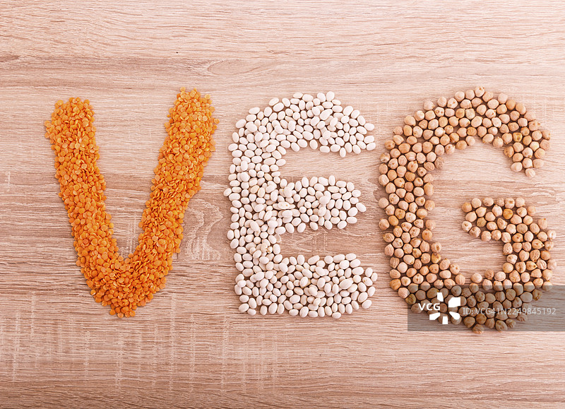 由扁豆、荞麦、豆类、大米和鹰嘴豆组成的“纯素”字样，背景为木质图片素材