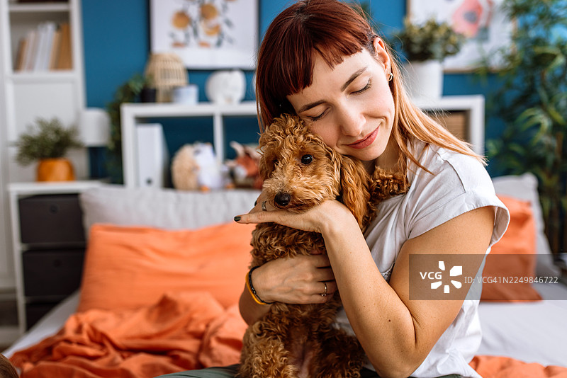 一只杏色贵宾犬幼犬的女人拥抱肖像图片素材