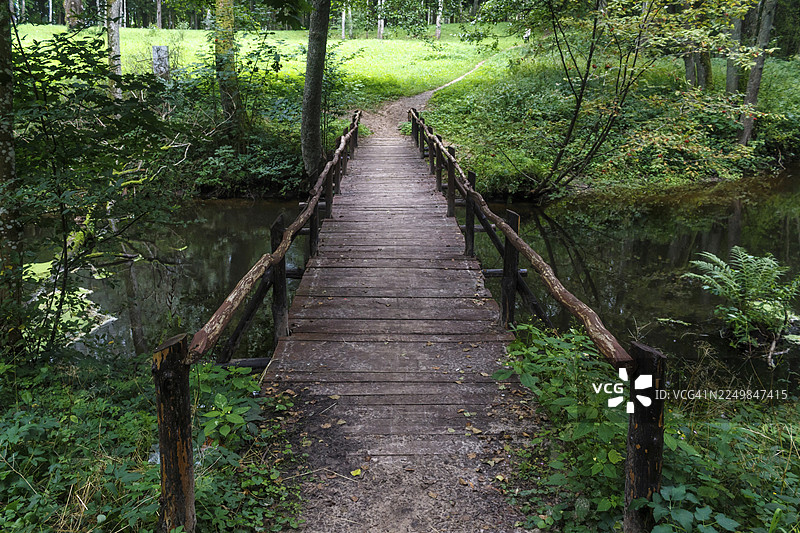 立陶宛德鲁斯基宁凯市公园里，一座木桥横跨河流。图片素材