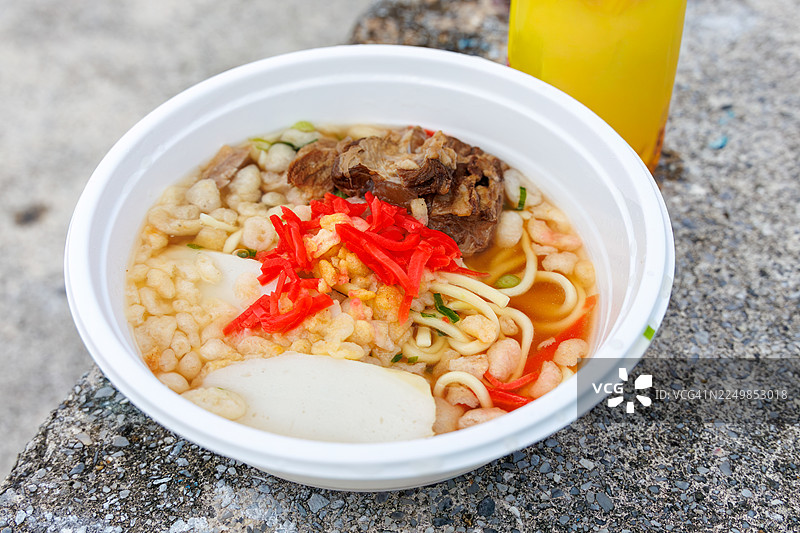 一大碗冲绳荞麦面作为早餐。上面铺着丰盛的炖猪软骨（Sōki），猪软骨用甜咸酱汁炖至软嫩。三品茶（冲绳风味的茉莉花茶）。冲绳座间味港。如同热带天堂般的离岛。图片素材