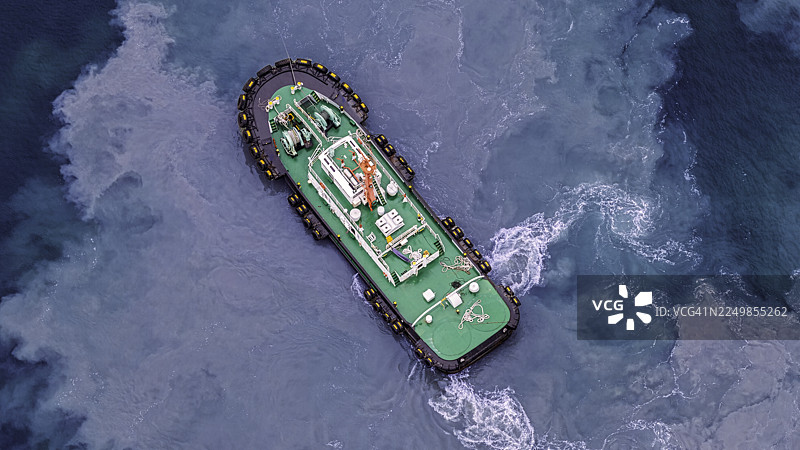 空中视角：拖船正在海上拖曳集装箱船。图片素材