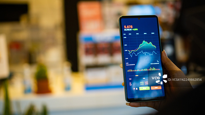 女性在手机交易平台App上在线投资股票图片素材