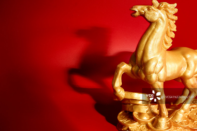 金色石头马雕像，背景为红色图片素材