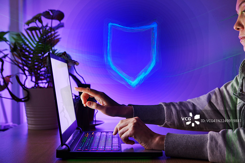 女性使用带有数字网络安全防护罩的笔记本电脑工作图片素材