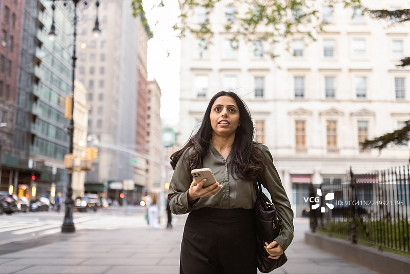 一位商务女性走在繁忙的城市区域图片素材