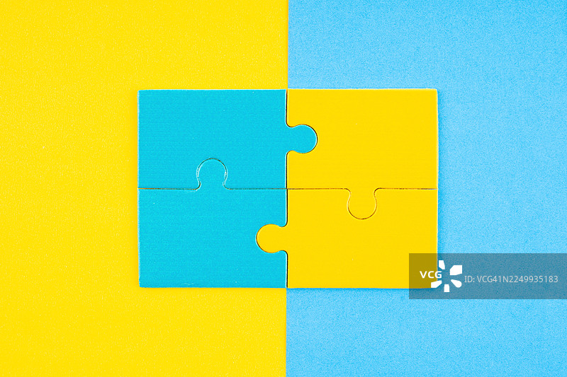 黄蓝背景上的四个黄蓝拼图块。图片素材