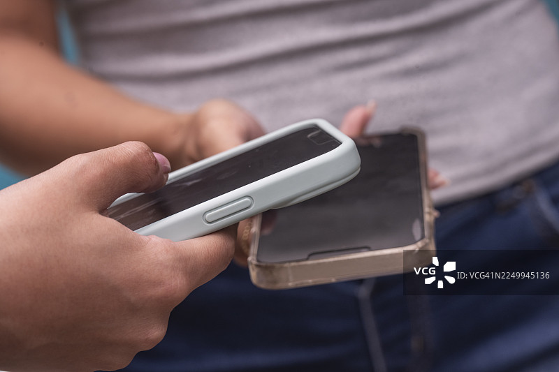 特写：两位女性手持智能手机图片素材