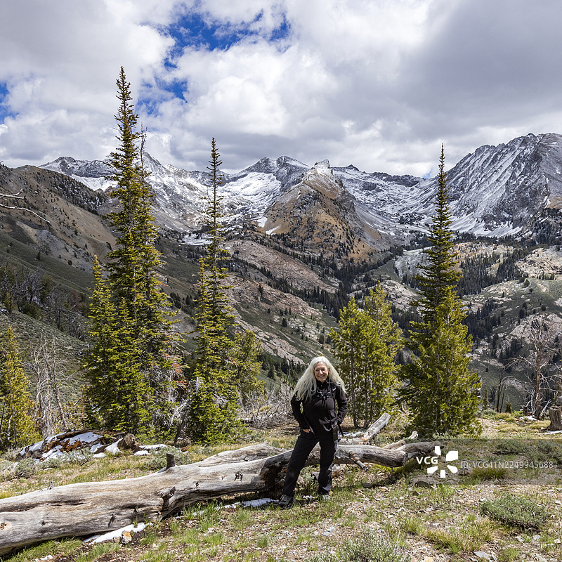 背景是白雪皑皑的先锋山脉，一位女性徒步者的肖像图片素材