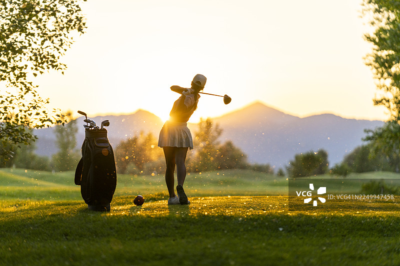 年轻的高加索女性高尔夫球手在球场发球区享受充满活力的挥杆图片素材