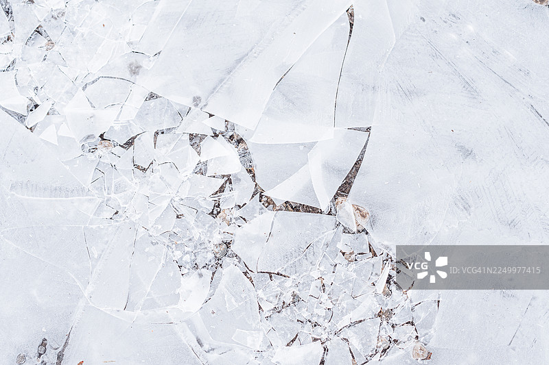 冰面碎裂，散落着玻璃碎片，呈现出寒冷冬季的纹理和抽象图案图片素材