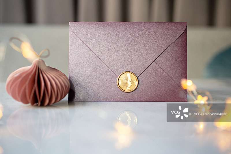 带蜡封的紫色金色证书礼品，旁边放着圣诞玩具。图片素材