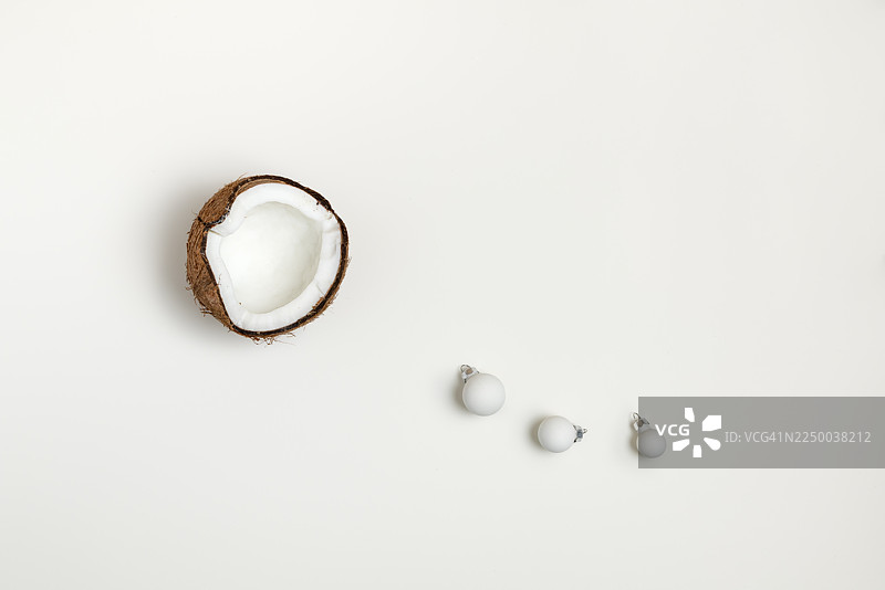 白色的圣诞装饰球和半个椰子图片素材