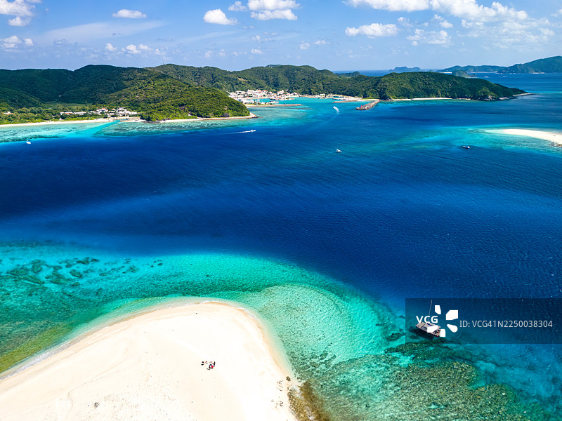 无人机航拍的庆良间群岛海景与岛屿，据说是世界上最美的。冲绳县渡嘉敷岛，热带鱼群，美丽的珊瑚礁和游泳的人们。座间味岛，庆良间群岛。图片素材
