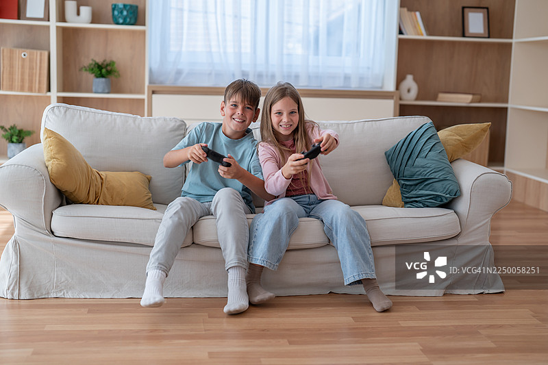 哥哥和妹妹在家一起玩电子游戏图片素材